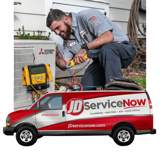 JD Service Now technician inspects a Mitsubishi heat pump outside a home