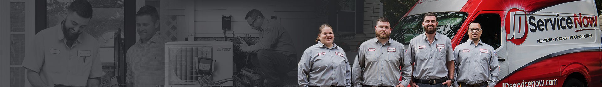 JD Service Now technicians standing, smiling in front of work truck