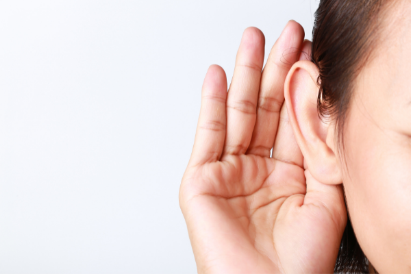 Hand next to ear to closely listen