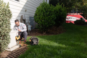 JD Service Now technician inspecting a home's outdoor AC unit