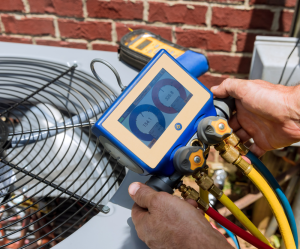 maintenance tech analyzing outdoor ac unit with tool