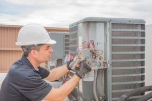 HVAC technician working on the wiring of an air conditioning system