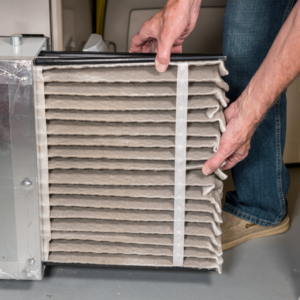 Person pulling out an old air filter.