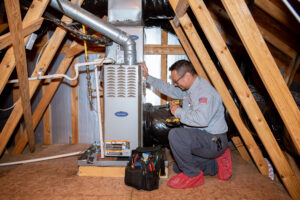 Technician inspects a furnace in a home's attic