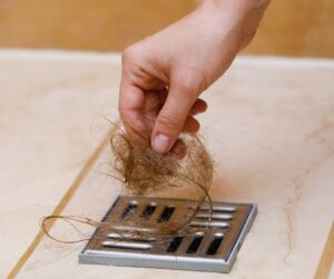 Hair being pulled from a square shower drain