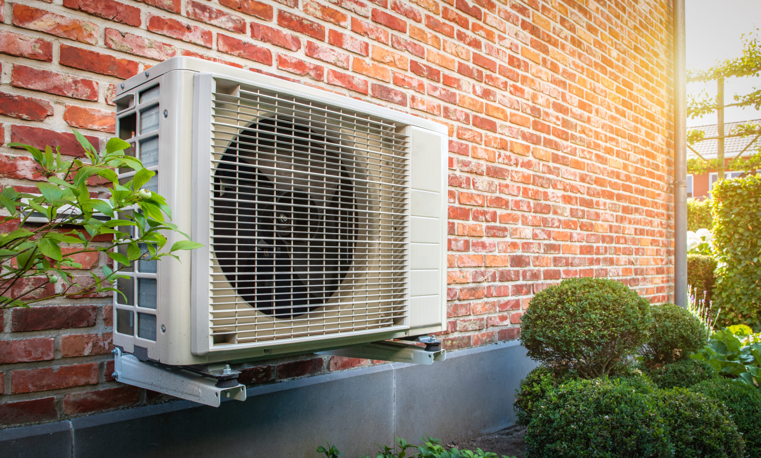 Heat pump unit outside a brick home.