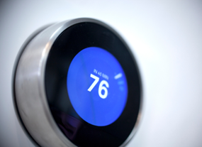 A smart thermostat with the temperature showing 76 degrees 